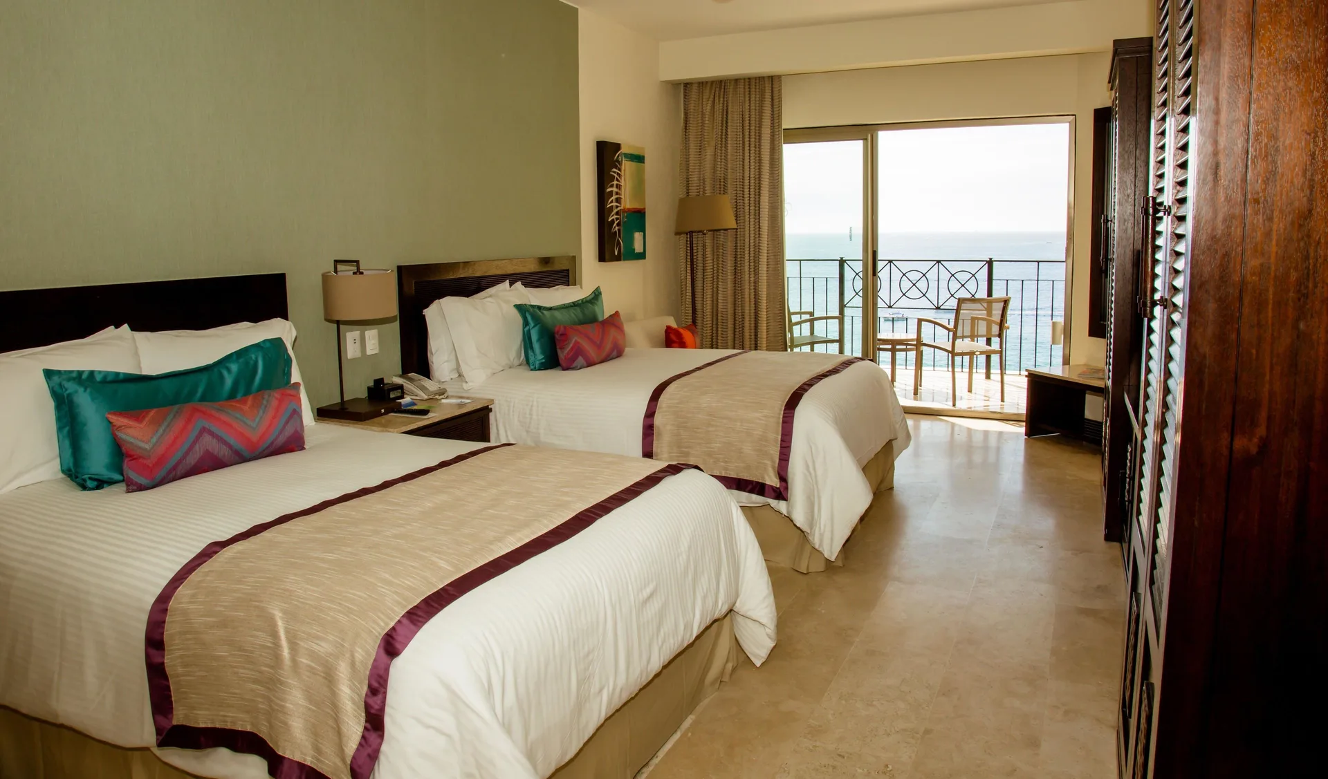 Two double beds and ocean-view balcony in a suite at Casa Dorada Los Cabos Resort & Spa.