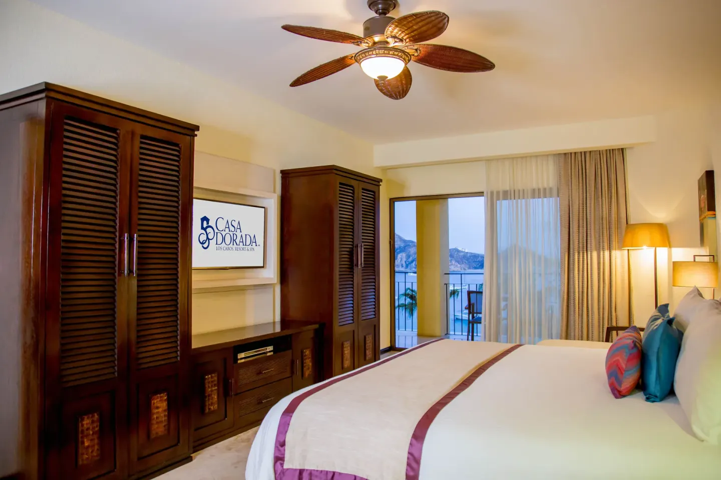Executive suite king bed with balcony doors at Casa Dorada Los Cabos Resort & Spa.