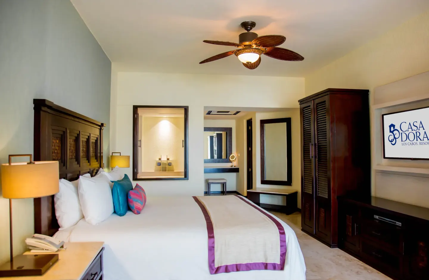 Executive suite bedroom with king bed and TV at Casa Dorada Los Cabos Resort & Spa.