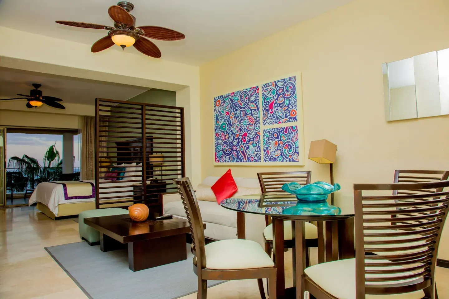 Junior suite dining table, sofa, and bedroom alcove at Casa Dorada Los Cabos Resort & Spa.
