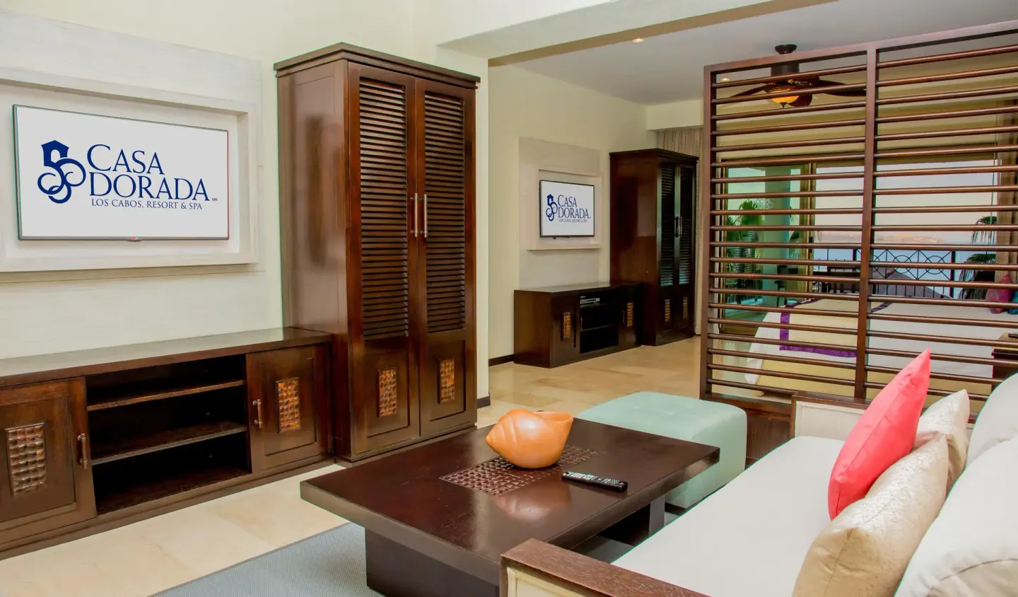 Junior suite sitting area with media cabinet and bed divider at Casa Dorada Los Cabos Resort & Spa.
