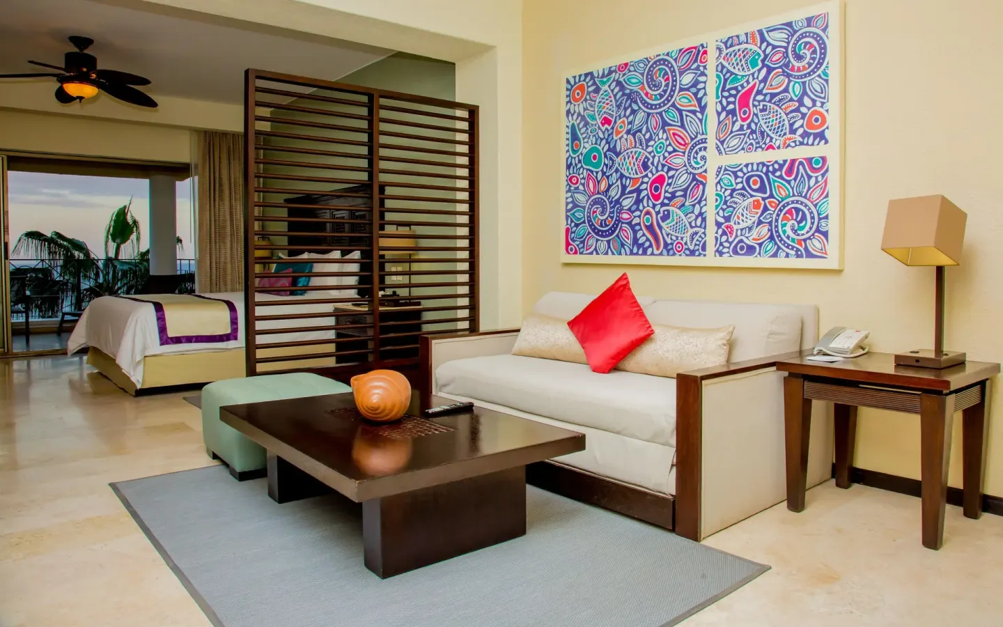 Junior suite sofa, coffee table, and king bed beyond at Casa Dorada Los Cabos Resort & Spa.