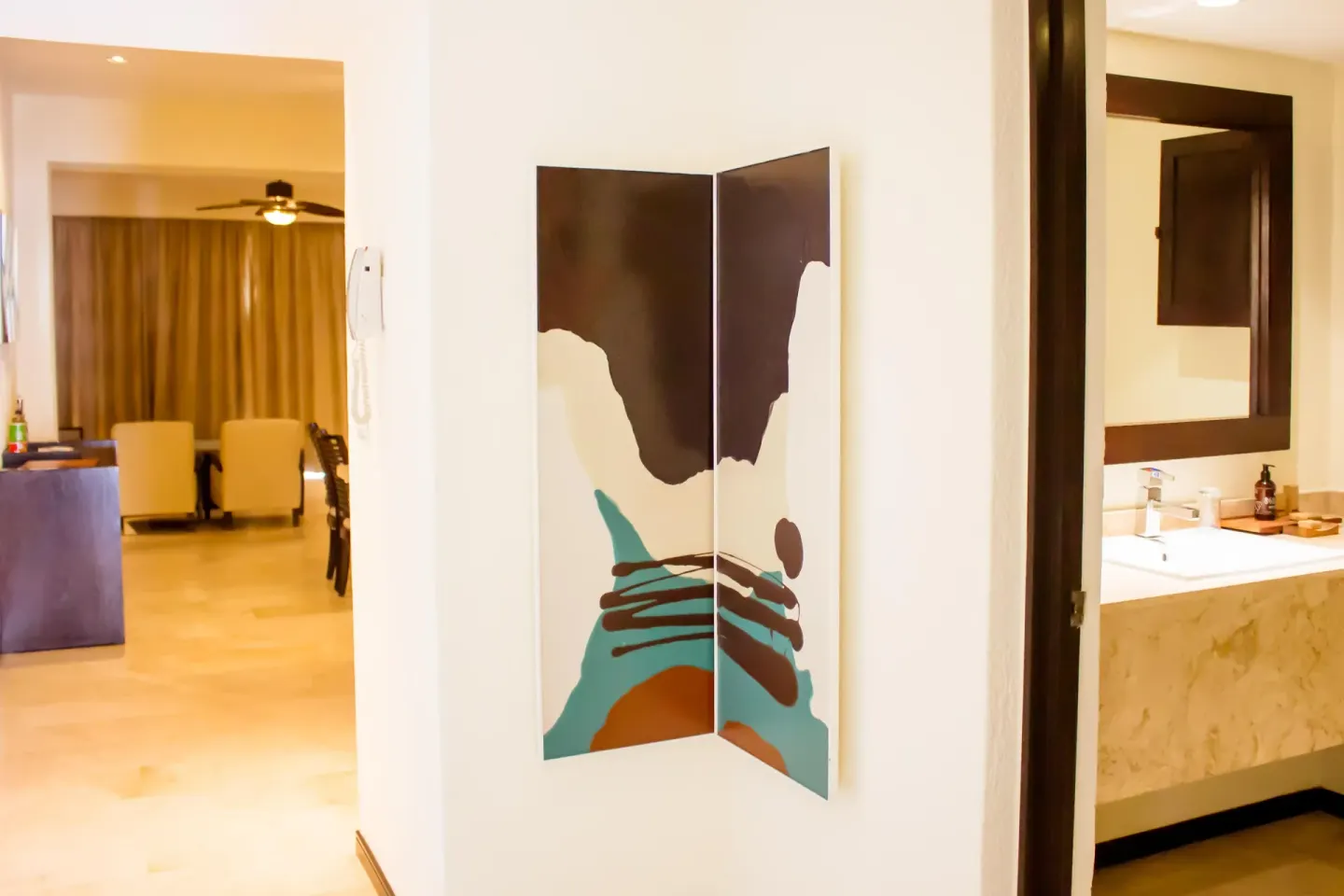 One Bedroom Plus hallway with wall art and bathroom view at Casa Dorada Los Cabos Resort & Spa.