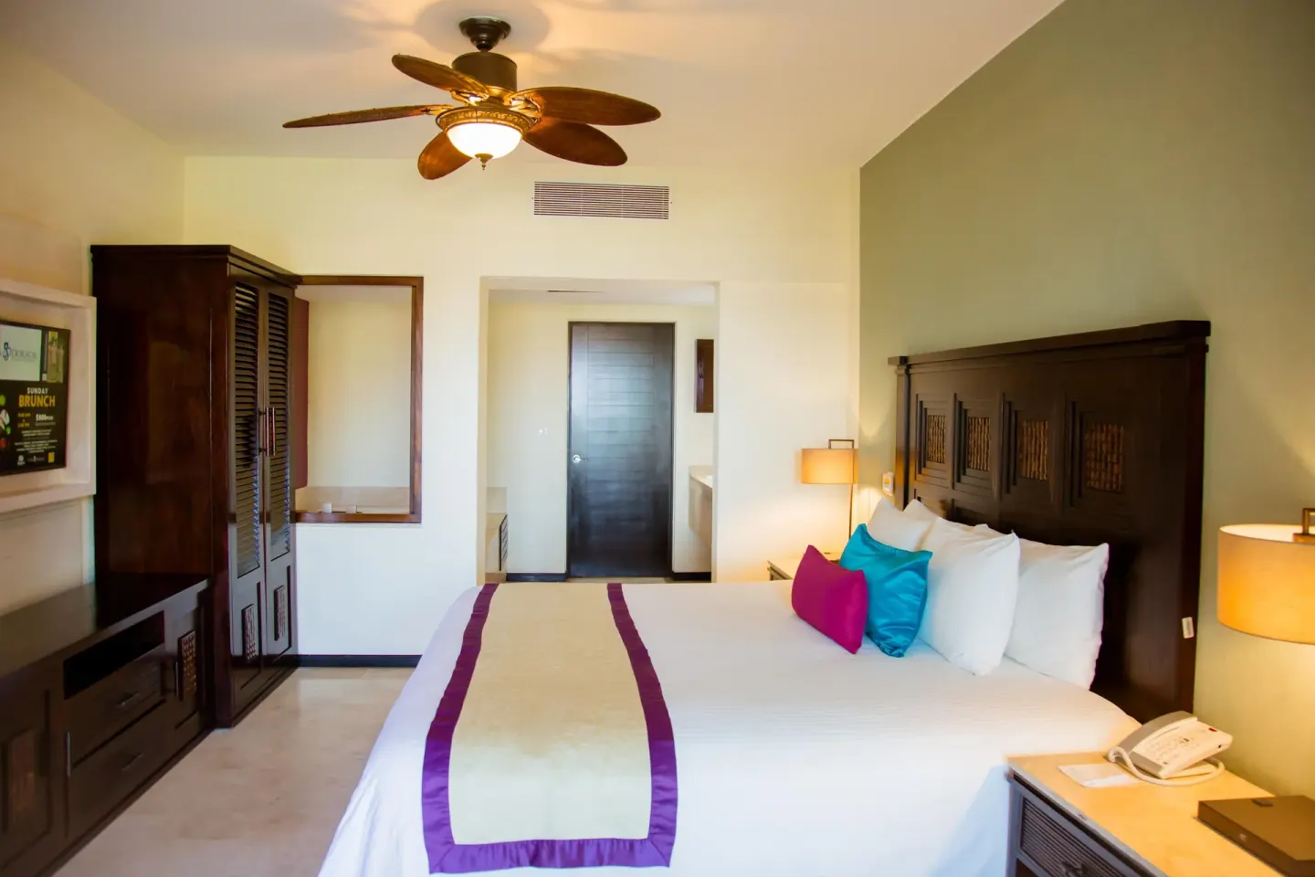 One Bedroom Plus king bedroom with dark wood headboard at Casa Dorada Los Cabos Resort & Spa.
