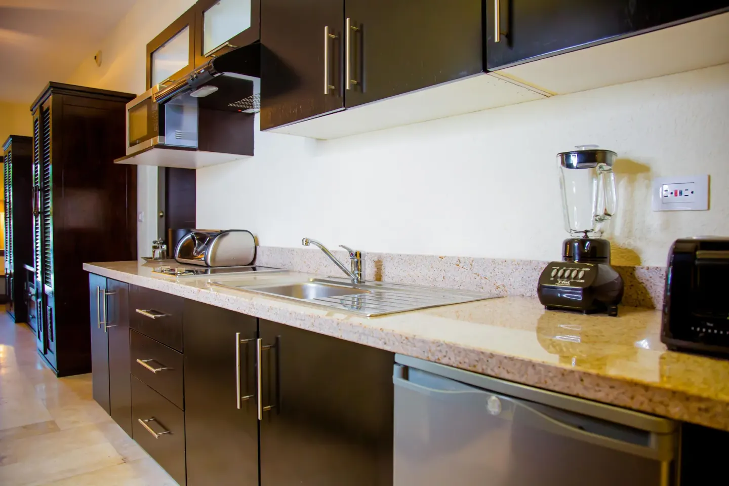 Standard room kitchenette with sink and appliances at Casa Dorada Los Cabos Resort & Spa.