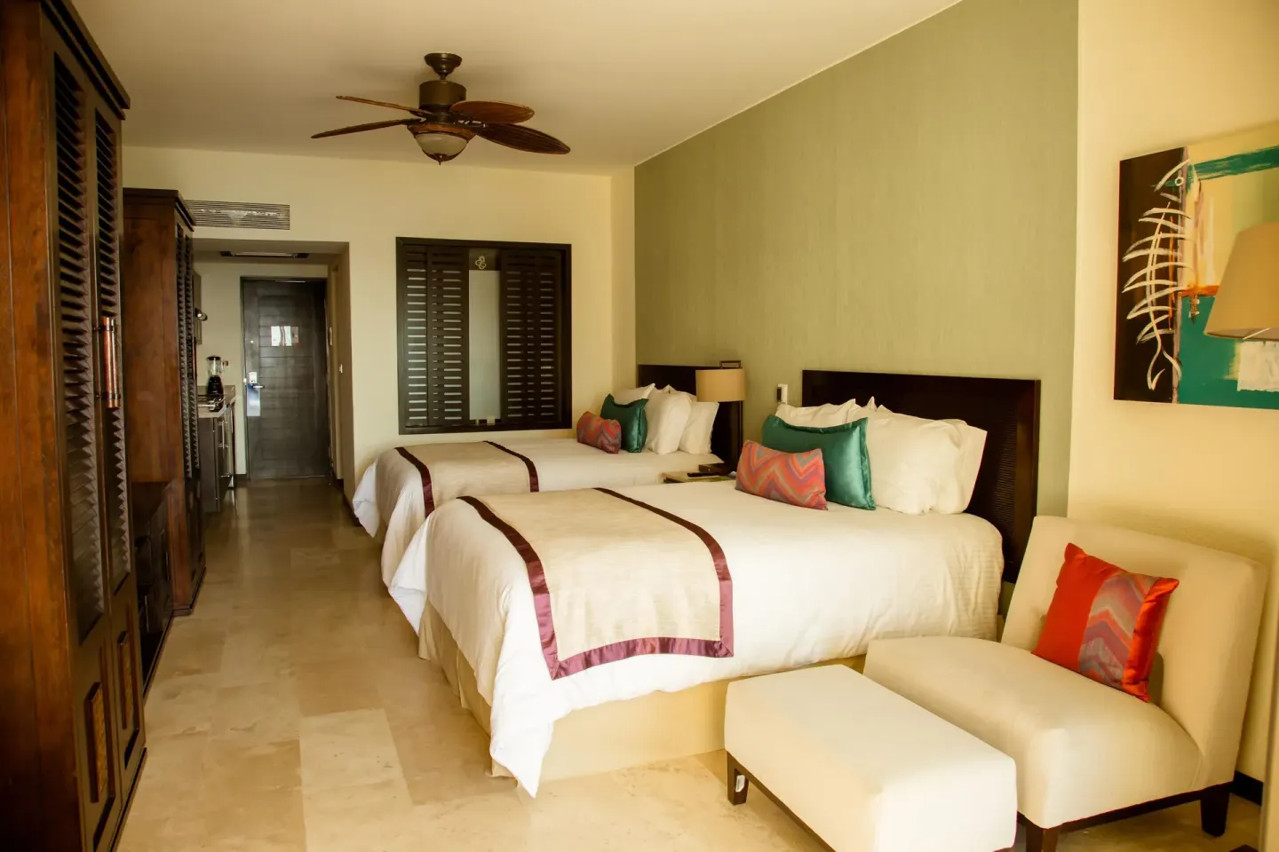 Two-bed standard garden view room with lounge chair at Casa Dorada Los Cabos Resort & Spa.
