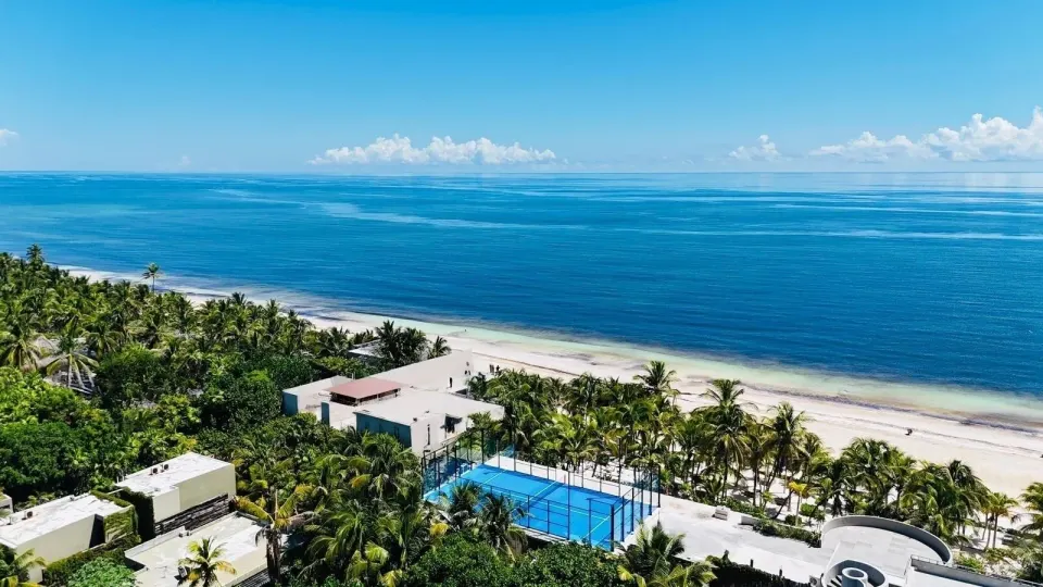 Aerial view of Casa Malca resort buildings, pool and the shoreline.