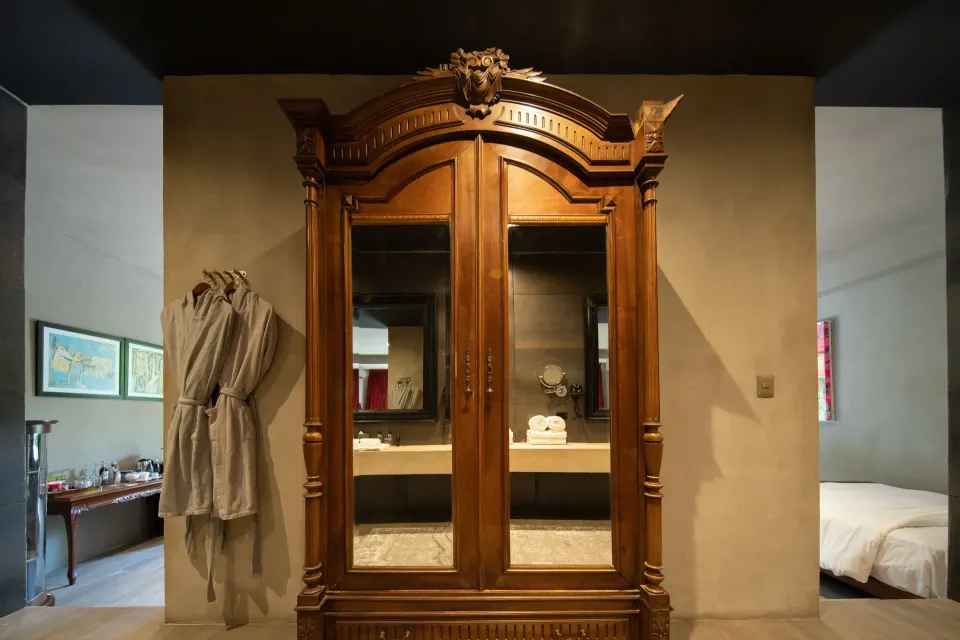 Antique wooden armoire and bathrobes between two sleeping areas at Casa Malca