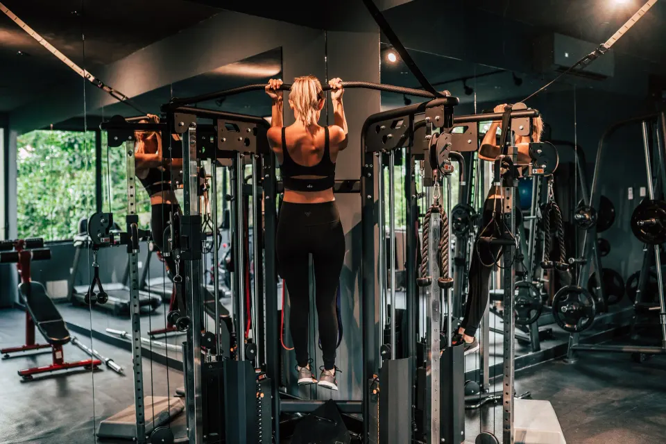 Guest performing pull-up in Casa Malca fitness center on a multi-station machine.