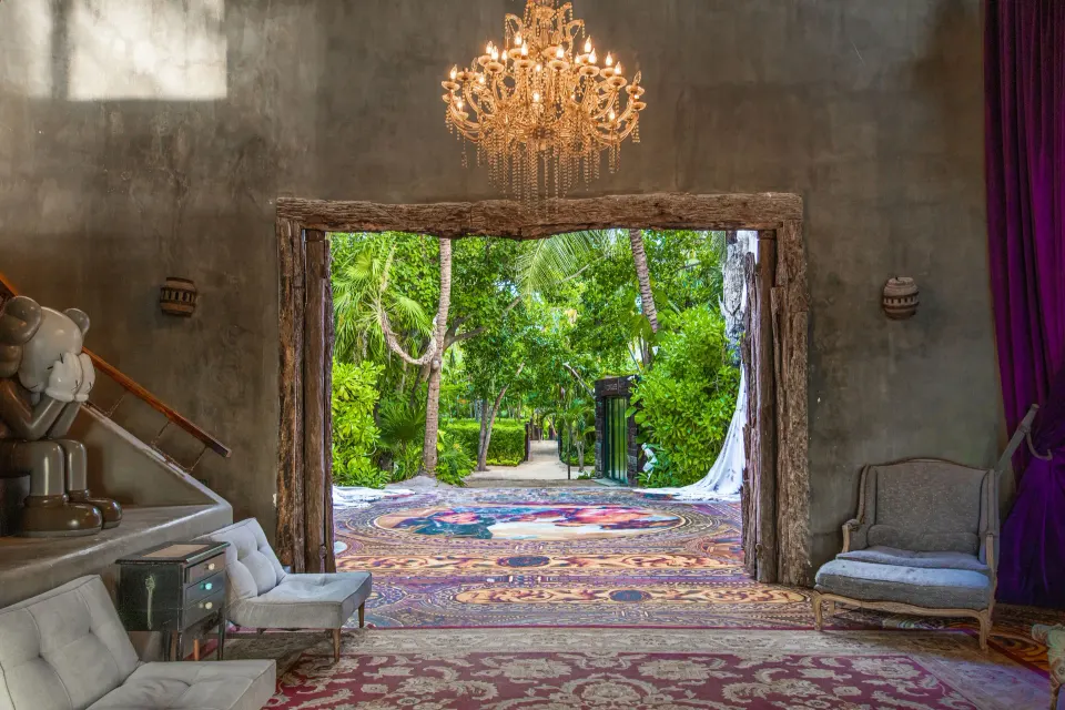 Interior doorway opening to a garden path with carpets and chandelier at Casa Malca.