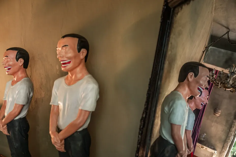 Three identical playful sculptures reflected in a mirror at Casa Malca.