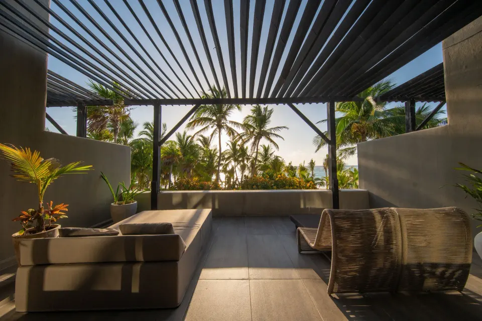 Shaded private terrace with seating and palm views at Casa Malca.
