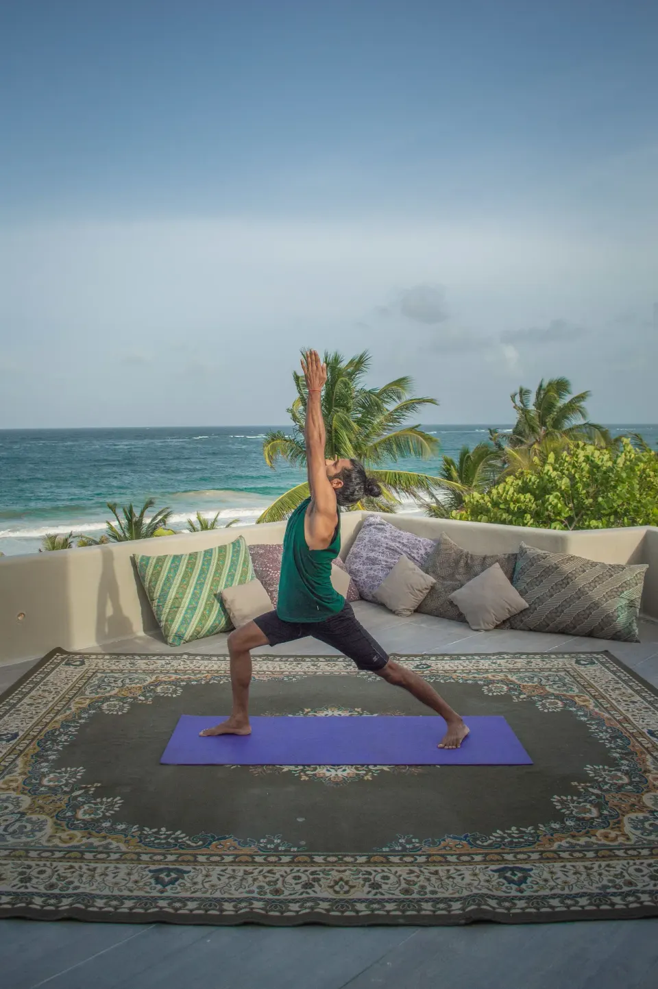 Yoga class on a seaside terrace at Casa Malca with ocean view behind the student.