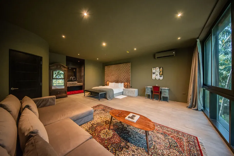 Spacious suite living area with sofa, coffee table and king bed at Casa Malca