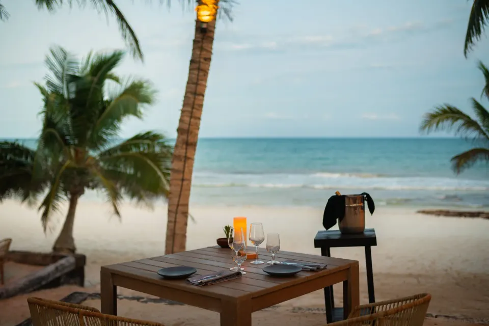 Beachside dining table set for two on the sand at Casa Malca