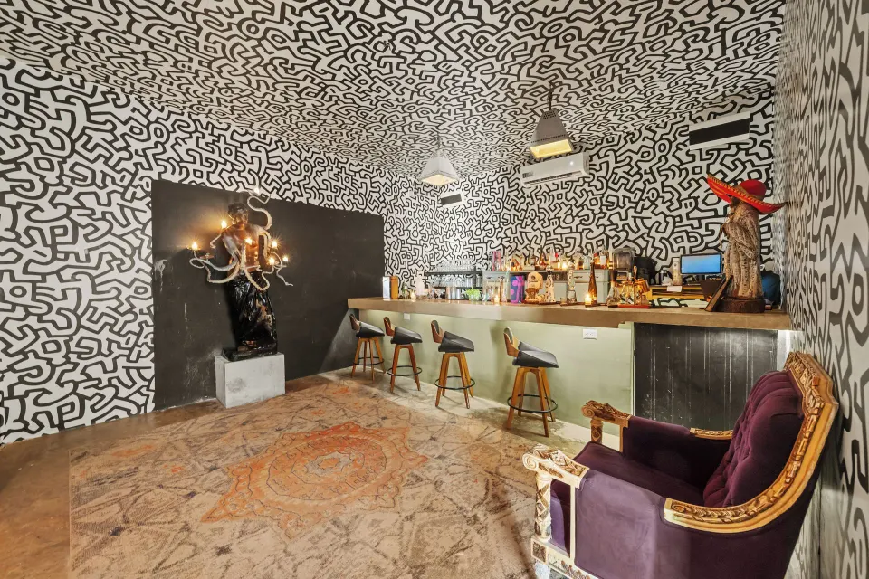 Eclectic bar interior with patterned walls and seating at Casa Malca