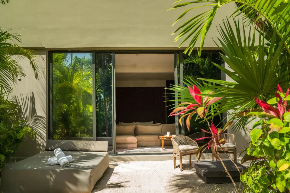 Family Suite garden terrace with lounge seating and sliding doors at Casa Malca