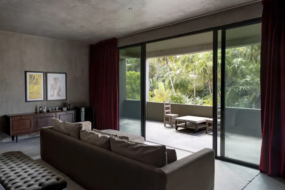 Living area of the Family Suite with sofa and sliding doors to a garden-view terrace at Casa Malca