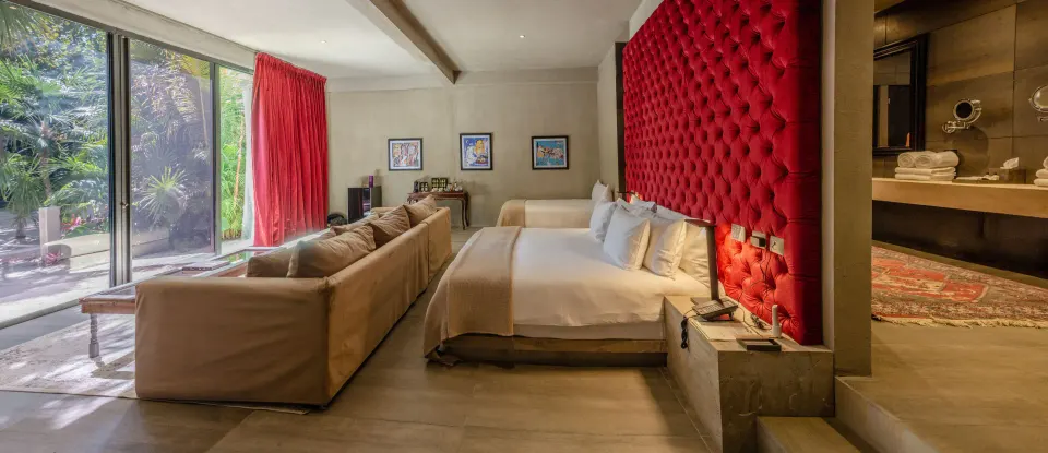 Panoramic view of Family Suite showing beds, sofa and sliding glass doors to the garden at Casa Malca