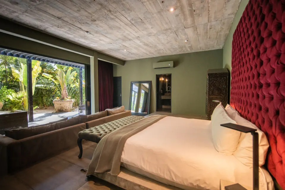 Junior Suite Garden View at Casa Malca with bed, sofa and open doorway to a small patio garden