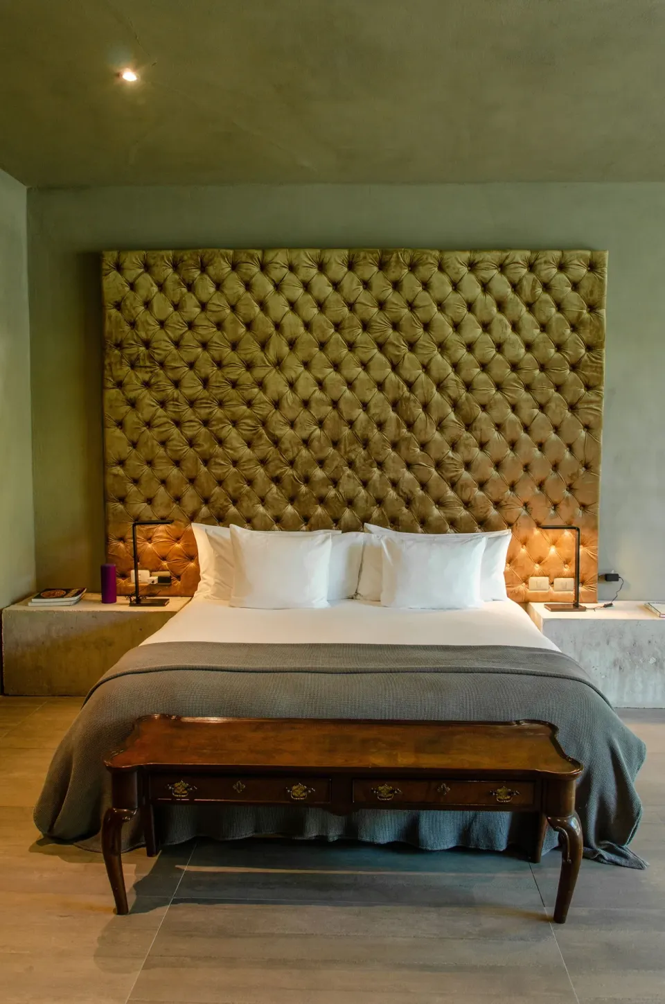 Close-up of king bed with tall tufted headboard in a Junior Suite Garden View at Casa Malca