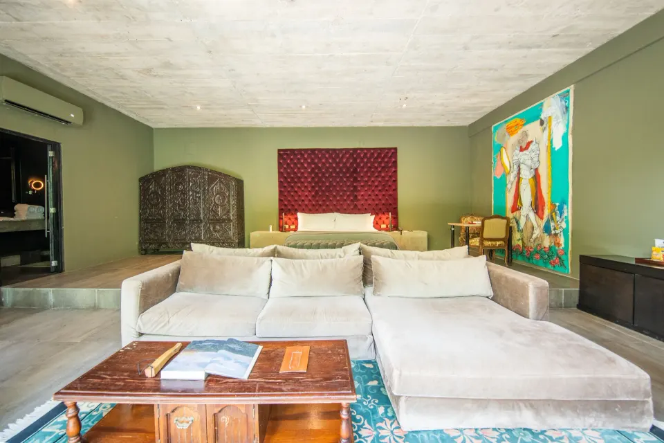 Junior Suite Garden View with king bed, red headboard and sofa from front at Casa Malca
