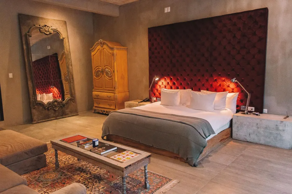 Junior Suite Garden View with king bed, red headboard and ornate mirror at Casa Malca