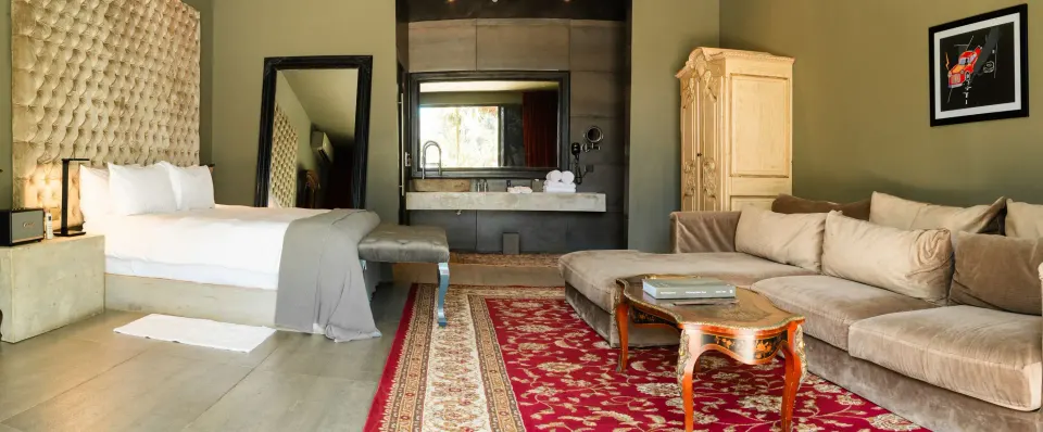 Junior Suite Garden View with king bed, neutral sofa and patterned area rugs at Casa Malca