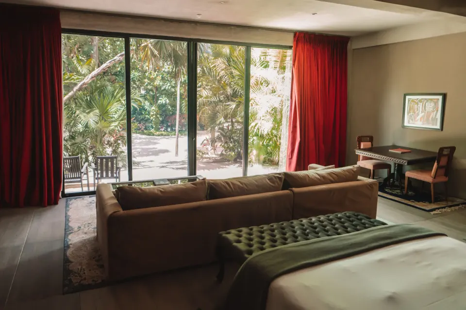 Junior Suite Garden View at Casa Malca with sofa facing floor-to-ceiling doors opening to the garden