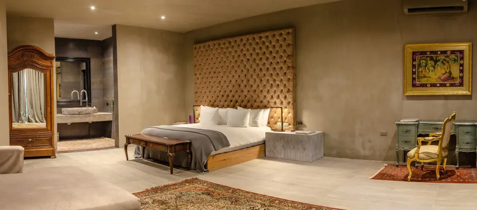 Spacious Suite with king bed, textured headboard and open vanity at Casa Malca