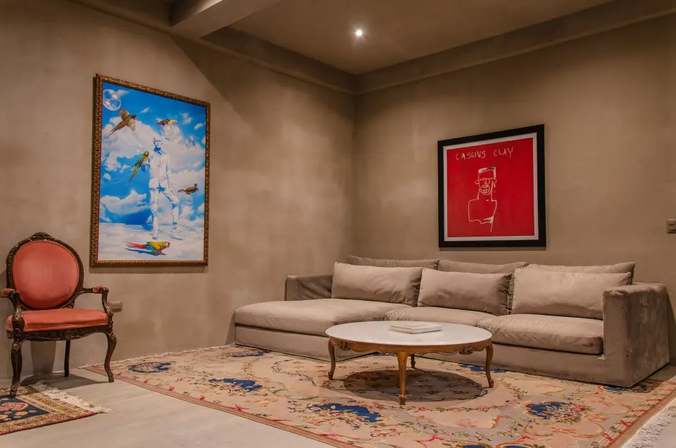 Suite seating area with sofa, vintage chair and artwork at Casa Malca