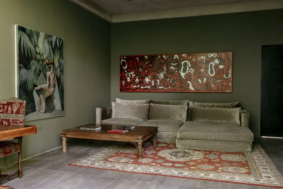 Suite sitting area with sectional sofa and artwork at Casa Malca
