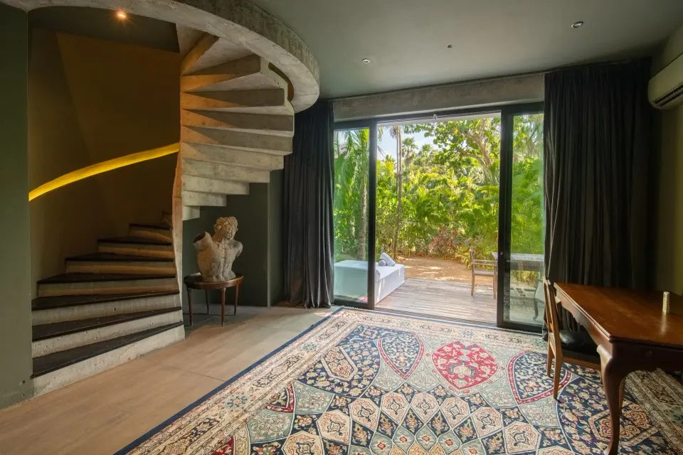 Townhouse bedroom interior with spiral staircase and garden view at Casa Malca
