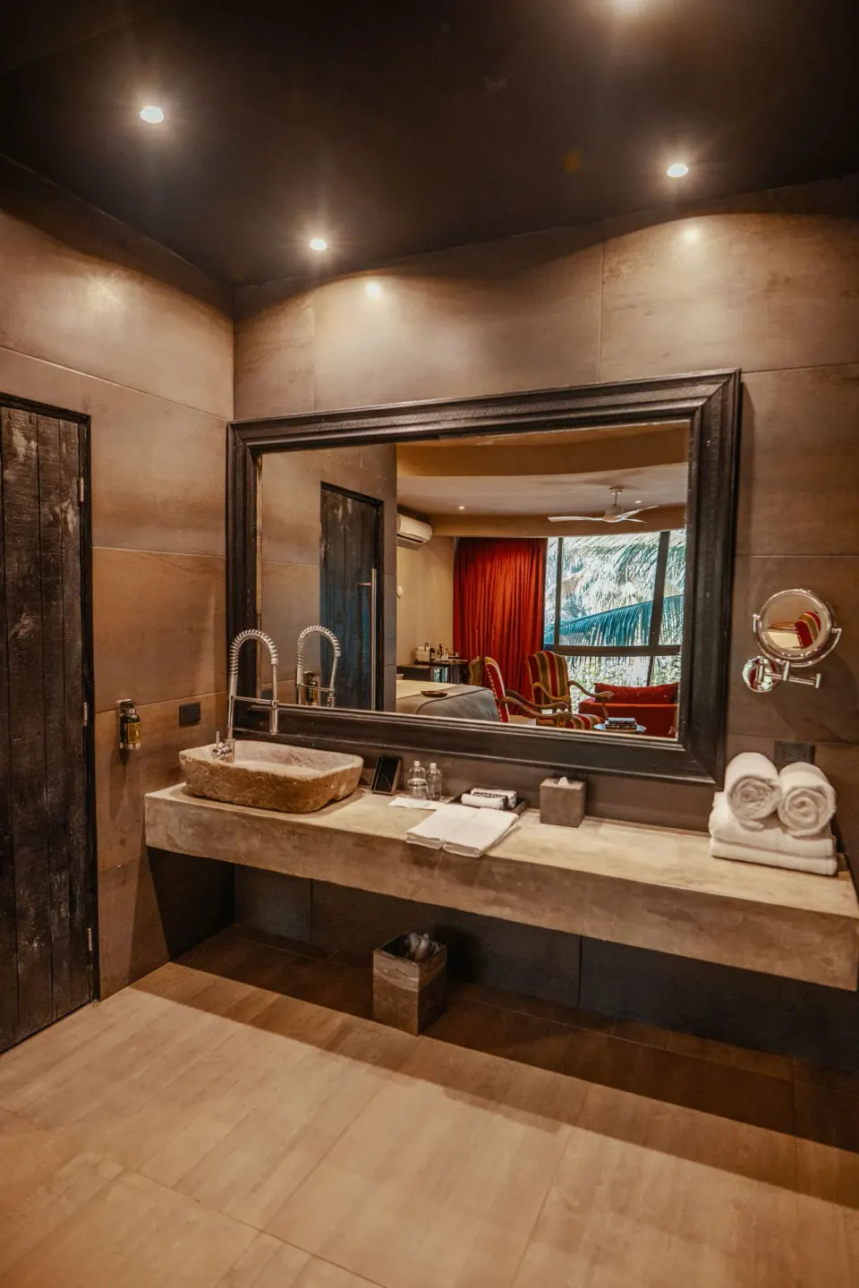 Suite bathroom sink and mirror with view of bedroom at Casa Malca