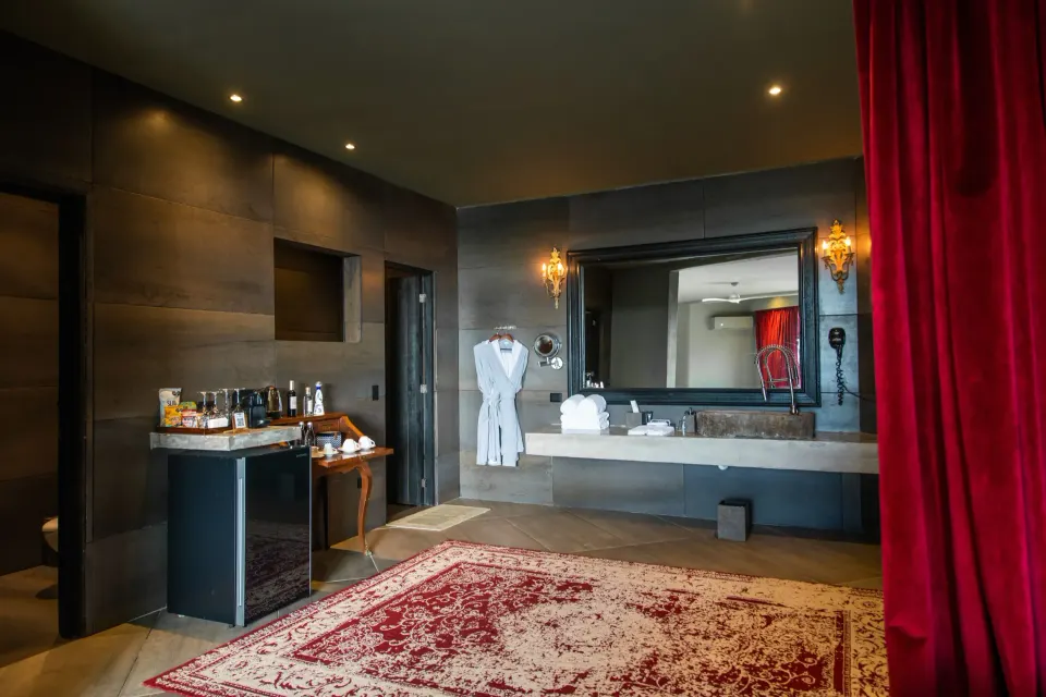 Spacious suite bathroom and dressing area with robes and a mini bar at Casa Malca.