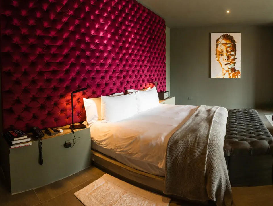 Master suite bedroom with tufted red headboard at Casa Malca