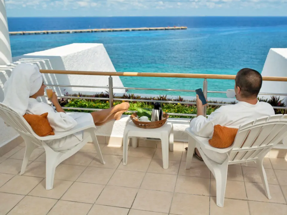 Couple relaxing on a balcony with ocean view at Casa Mexicana Cozumel