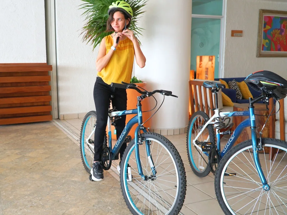 Guest standing with bicycles in the Casa Mexicana Cozumel lobby area.