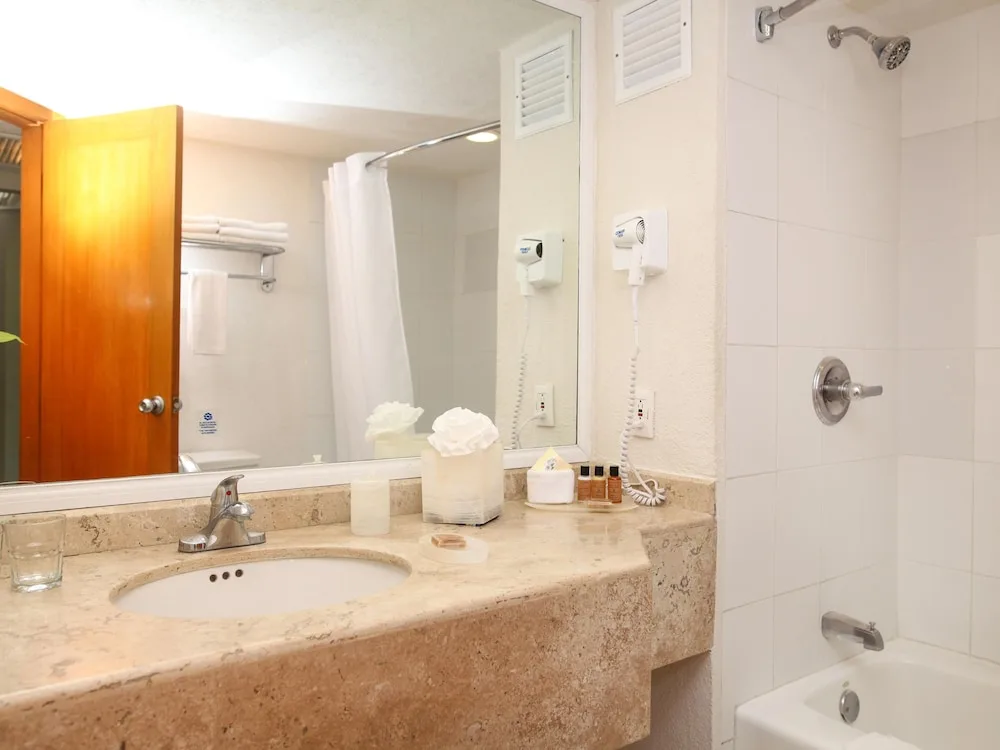Hotel bathroom vanity and tub with marble countertop at Casa Mexicana Cozumel