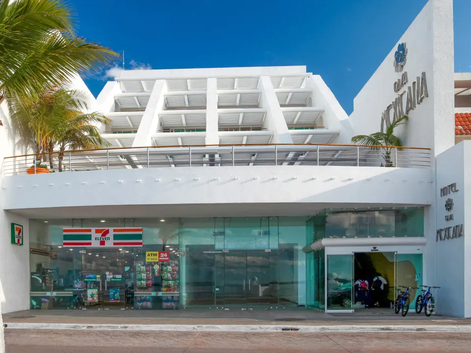 Front exterior of Casa Mexicana Cozumel with white facade and street-level shop.