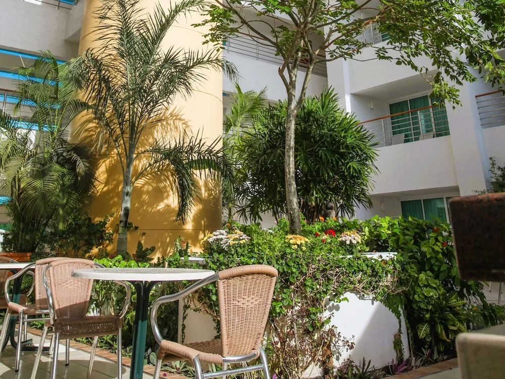 Hotel interior courtyard at Casa Mexicana Cozumel with tropical plants and outdoor seating