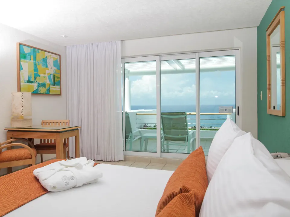 King bed and balcony with ocean view in a guest room at Casa Mexicana Cozumel