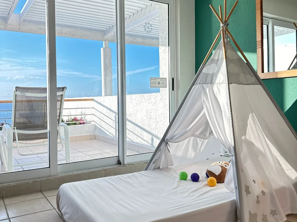 Children's play tent on a low bed with terrace and ocean view at Casa Mexicana Cozumel.