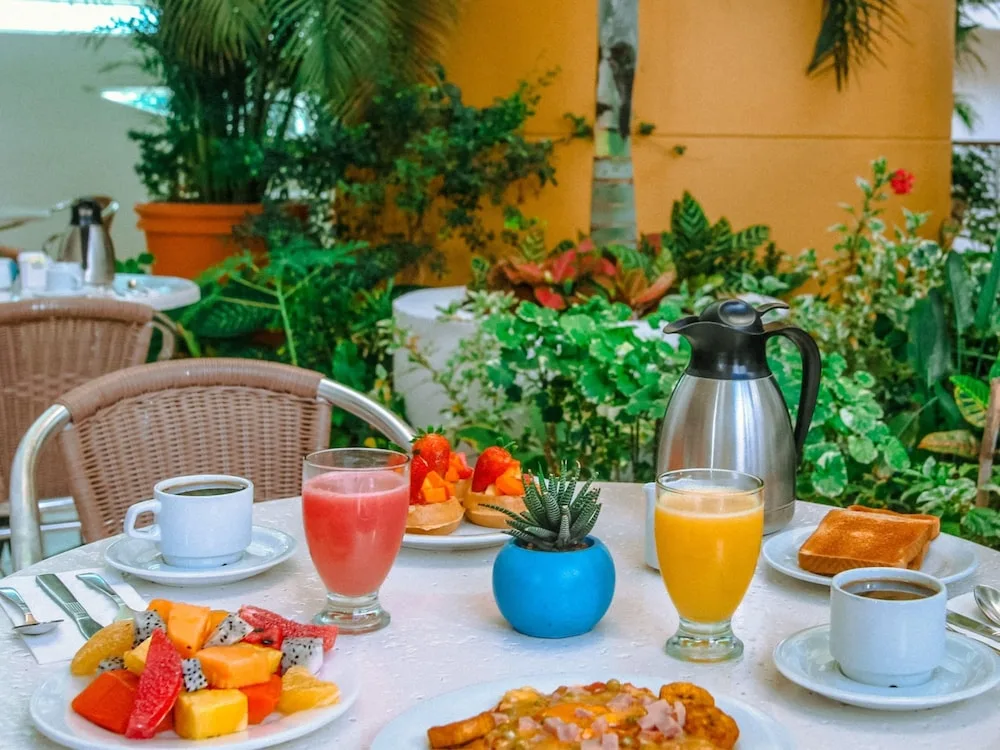 Outdoor breakfast table with fresh fruit, juice and coffee at Casa Mexicana Cozumel