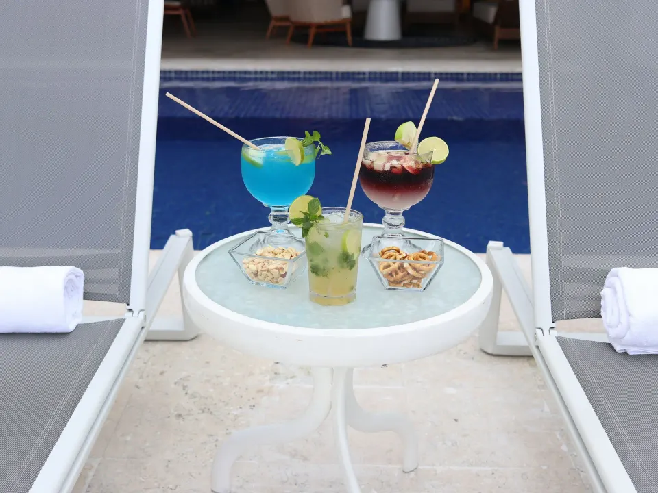 Three poolside cocktails on a small table at Casa Mexicana Cozumel