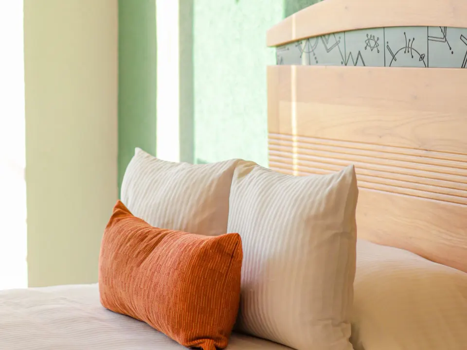 Close-up of pillows and headboard in a Habitacion Deluxe at Casa Mexicana Cozumel