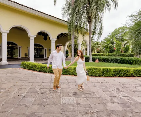 Couple walking on a stone path outside the arched entrance at Casa Velas.