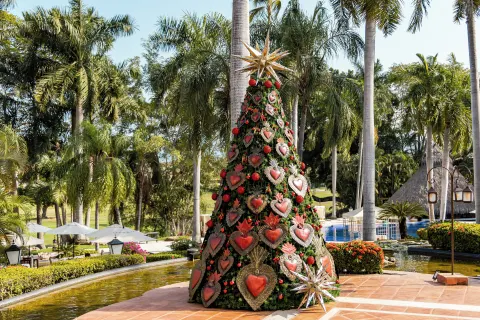 Festive decorated tree beside tropical gardens and pool at Casa Velas.