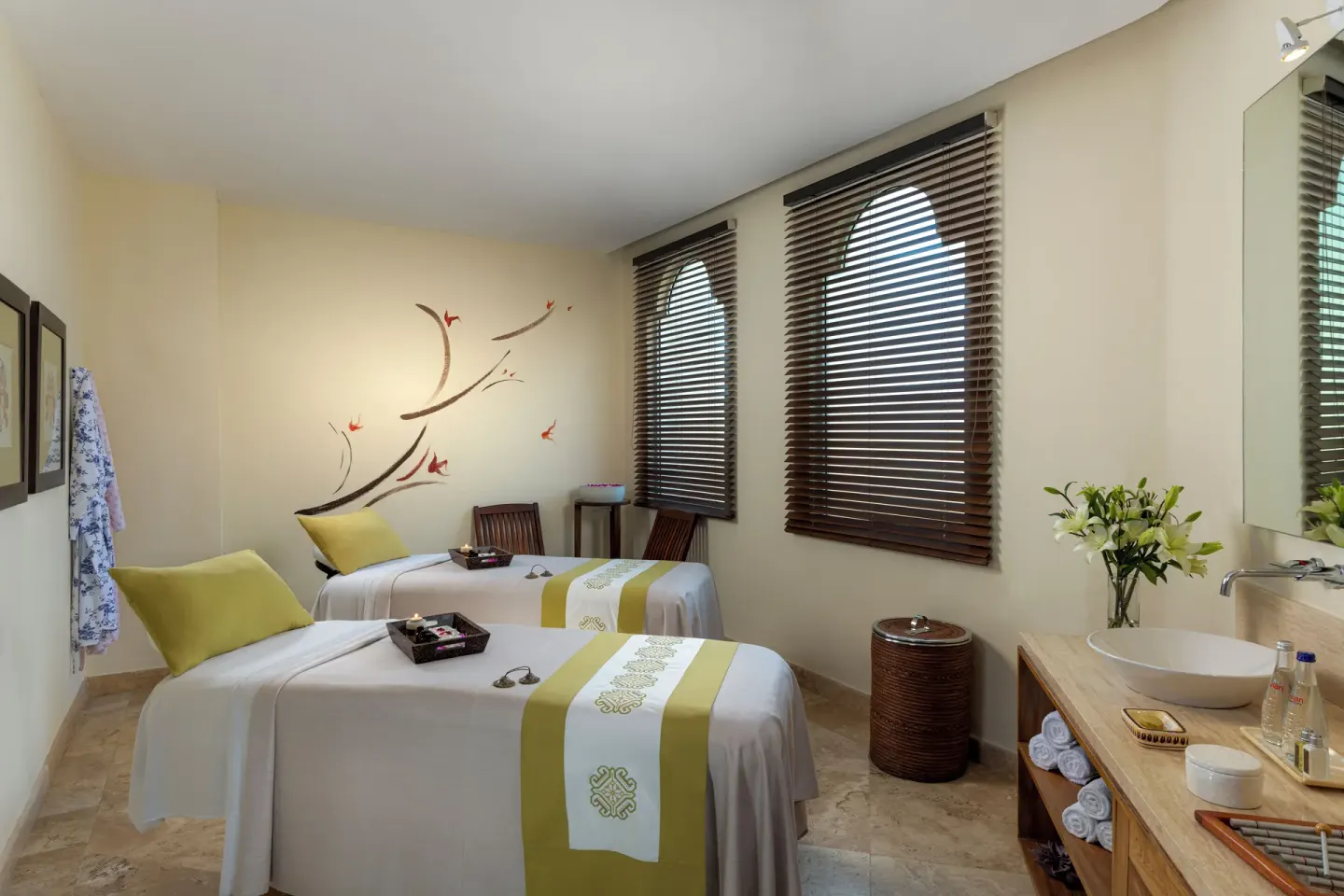 Spa treatment room with two massage beds and a vanity at Casa Velas.