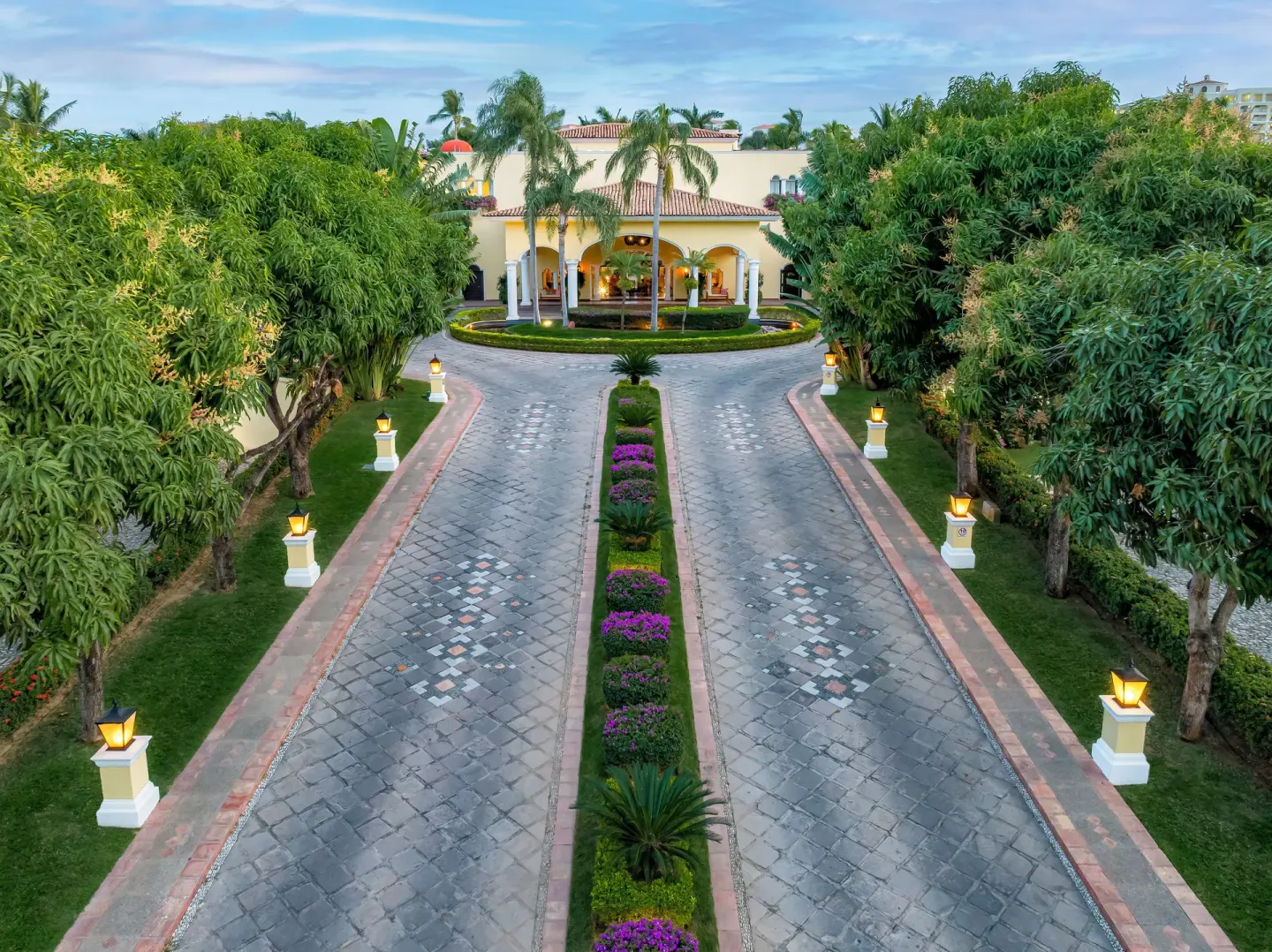 Tree-lined driveway with lanterns and gardens leading to Casa Velas.